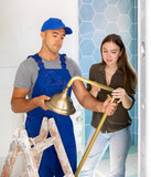 Landlady consults with a professional builder about installing a new shower in a remodeling bathroom.