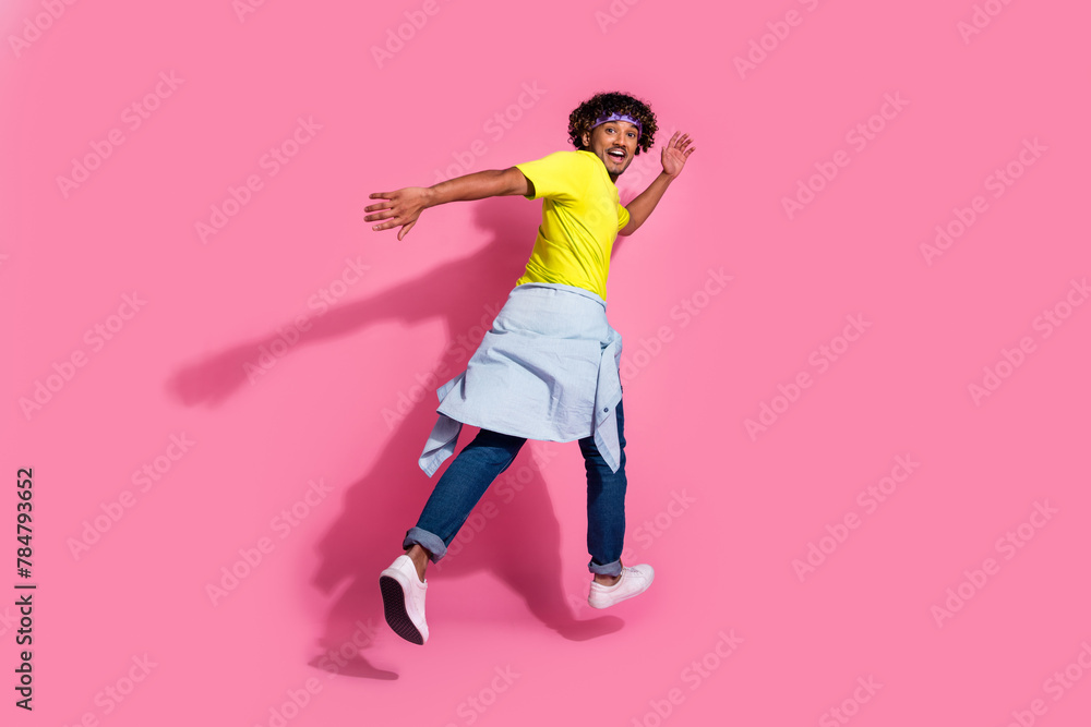 Photo of crazy cool positive man wear trendy yellow clothes run away empty space isolated on pink color background