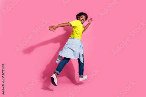 Photo of crazy cool positive man wear trendy yellow clothes run away empty space isolated on pink color background