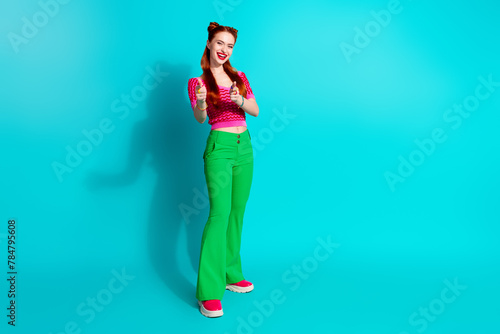 Full length photo of cool pretty lady dressed pink knitted shirt pointing you two fingers emtpy space isolated blue color background