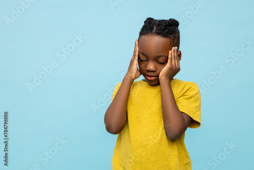 Sick dark- skinned little boy suffering headache