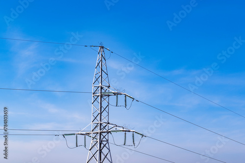 Obraz na płótnie Energy infrastructure. High voltage electric transmission pylon, or tower, against blue sky. Close-up. Copy space. w salonie