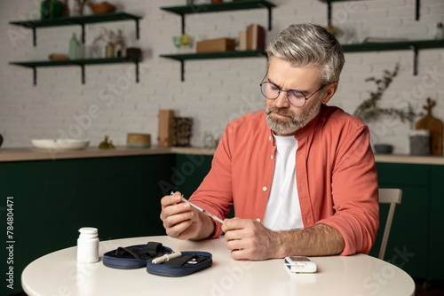 Caucasian diabetic man with insulin syringe injection sitting at table