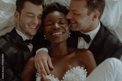 The concept of a threesome. A woman and two men in love. An African woman in a wedding dress and two men in suits in the same bed. Polygamy or bigamy.