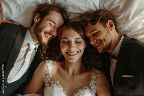 The concept of a threesome. A woman and two men in love. A woman in a wedding dress and two men in suits in the same bed. Polygamy or bigamy. photo