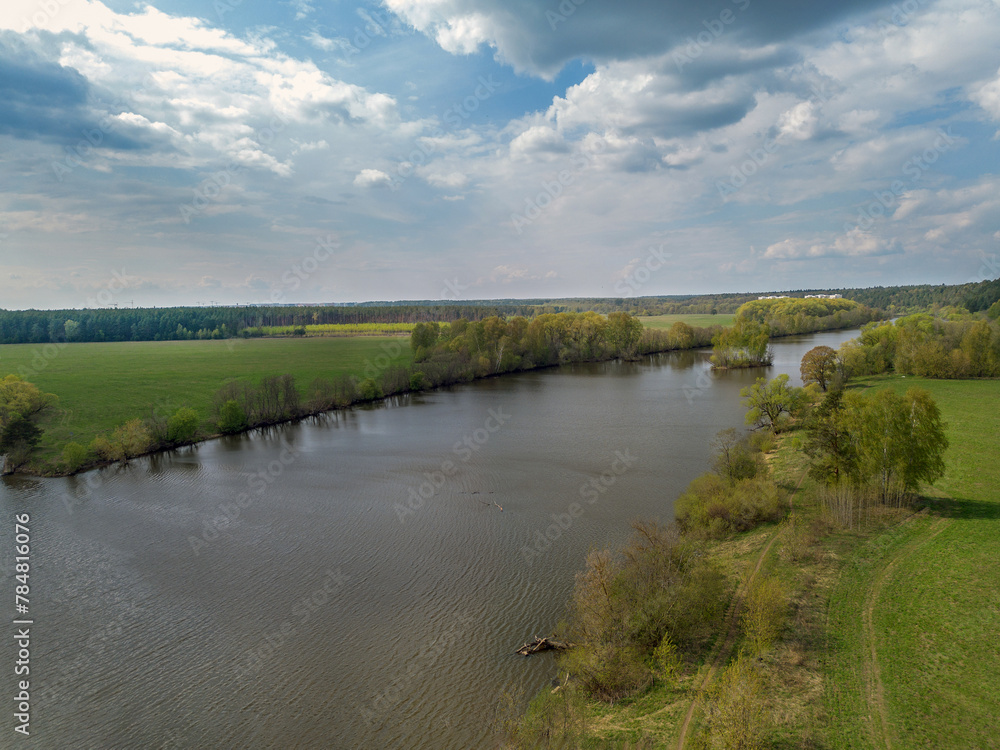 Drone view on River Moskva (Staritsa -old course) , forest  with fence. In distance 2 white buildings of military sanatorium of Arkhangelskoe estate