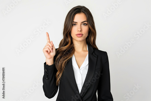 Portrait of a beautiful young woman in a business suit and white shirt who raised her index finger on a white background
