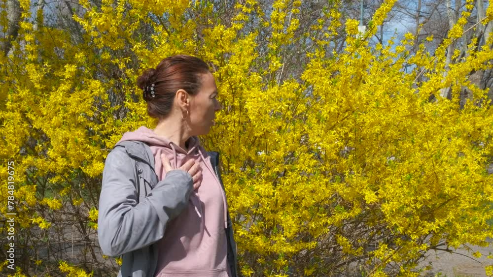 Woman having pollen allergy symptoms. A stressed woman feel unhappy because of pollen allergy by the blooming bushes. Woman having pollen allergy symptoms. A stressed woman feel unhappy because of pollen allergy by the blooming bushes.