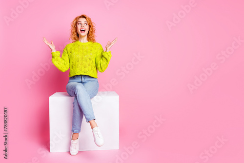 Photo of funky cheerful cute woman dressed stylish green clothes sitting cube empty space isolated on pink color background