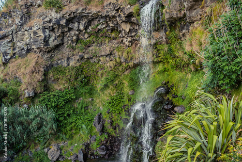 Detail of stream water in motion flowing into cliff and falling into rock, waterfall at Viola beach, São Miguel - Azores PORTUGAL