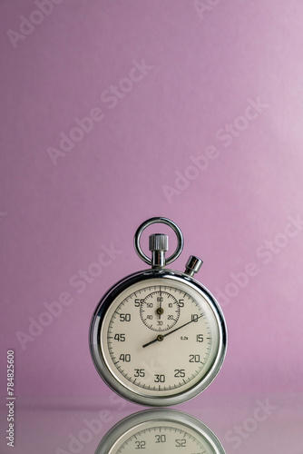 Old clock on a lilac background. Stopwatch in work.