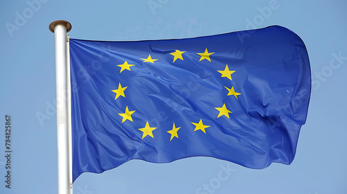 An image featuring the flag of the European Union flying proudly against a clear blue sky. The vibrant blue background is adorned with a circle of twelve golden stars