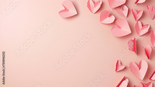 pink paper hearts on the side of soft pink background, space for text