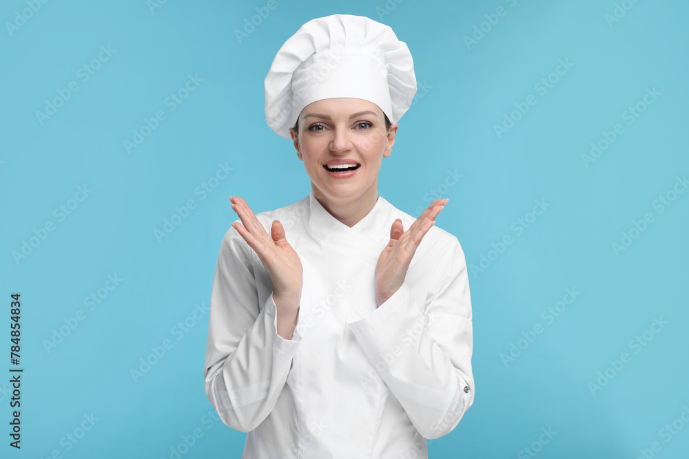 Happy chef in uniform on light blue background Happy chef in uniform on light blue background