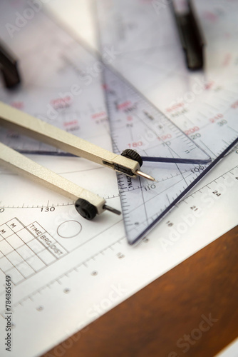 Above image of a navigator's radar plotting chart with a triangler and compass divider