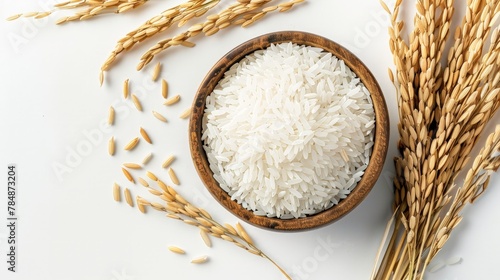 White rice, natural long rice grains (Thai jasmine rice) in wooden bowl with paddy rice isolated on white background. Top view. flat lay.