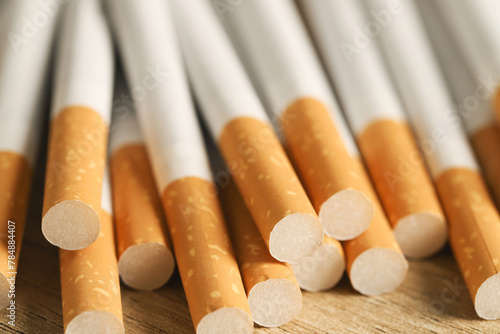 image of several commercially made pile cigarette on wood background. or Non smoking campaign concept, tobacco pattern top view photo