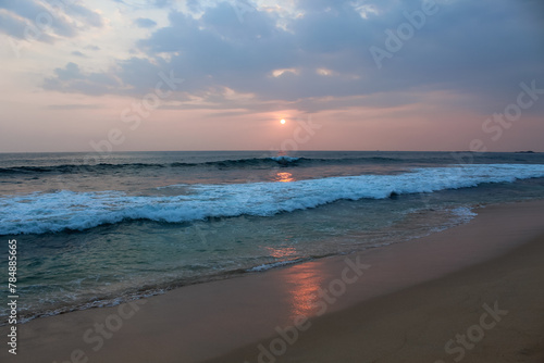 The sun setting into the sea at Delawella beach  Sri Lanka. Golden light