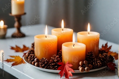 Beautiful burning candles on the table in a living room with autumn decoration.