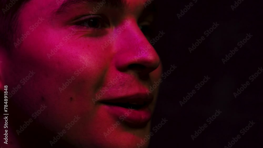 Man in close up laughs in slow motion in a dark room Man in close up laughs in slow motion in a dark room