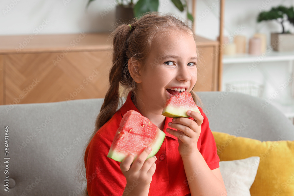 Happy little girl with fresh watermelon sitting on sofa in living room Happy little girl with fresh watermelon sitting on sofa in living room