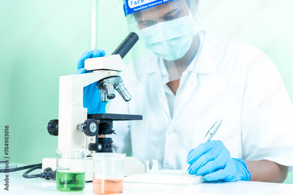 Scientist man look into Microscope research in science laboratory. Asian scientist looking equipment laboratory chemistry labs. Covid-19 coronavirus biochemistry research experiment vaccine concept Scientist man look into Microscope research in science laboratory. Asian scientist looking equipment laboratory chemistry labs. Covid-19 coronavirus biochemistry research experiment vaccine concept