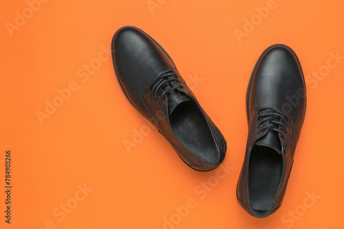 Men's shoes are black on an orange background.
