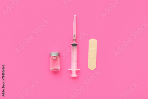 Empty syringe, ampoule and plaster on pink background