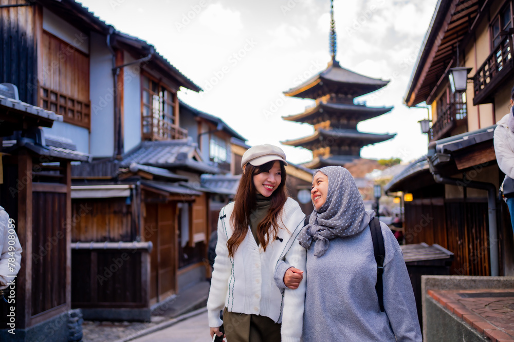 Travel, muslim travel,  woman girl tourist Two Asian friends but different religions walking at Yasaka Pagoda and Sannen Zaka Street in Kyoto Japan, Yasaka Pagoda is the famous landmark and travel.