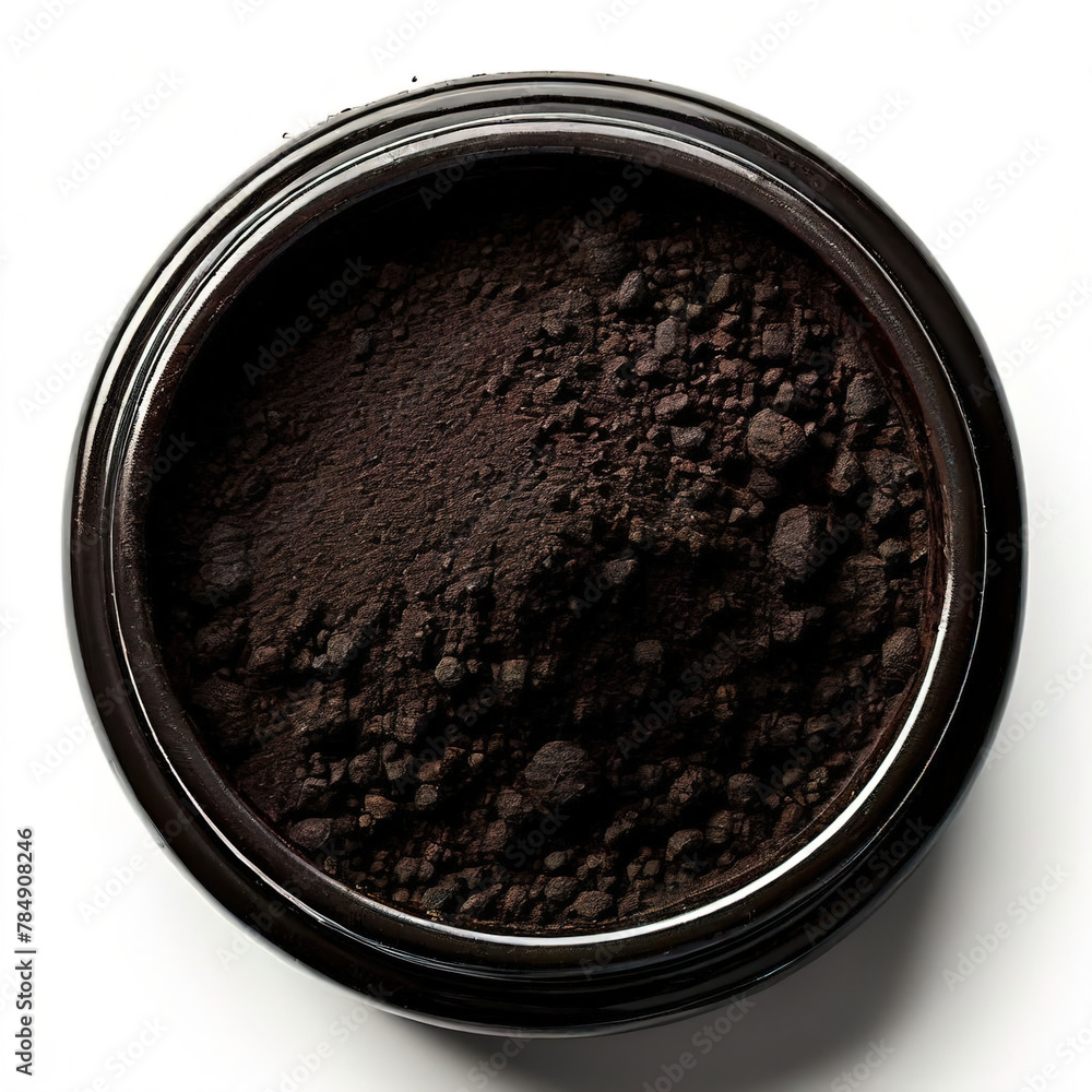 Activated charcoal powder for cosmetic face mask in a jar top view with copy space Activated charcoal powder for cosmetic face mask in a jar top view with copy space