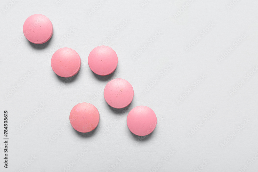 Pink pills on white background