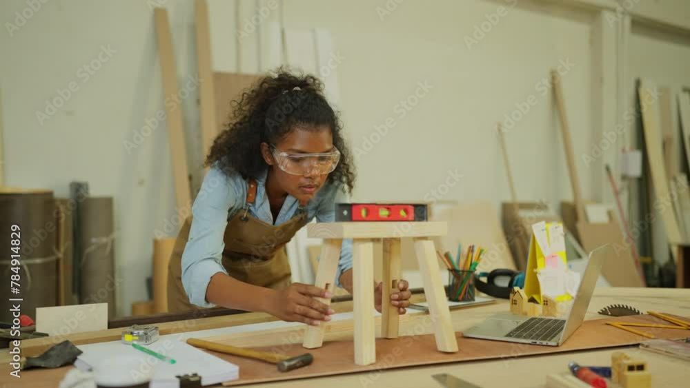 Professional carpenter or woodworker or charpentier woman use level to check wood work product in workplace. Professional carpenter or woodworker or charpentier woman use level to check wood work product in workplace.