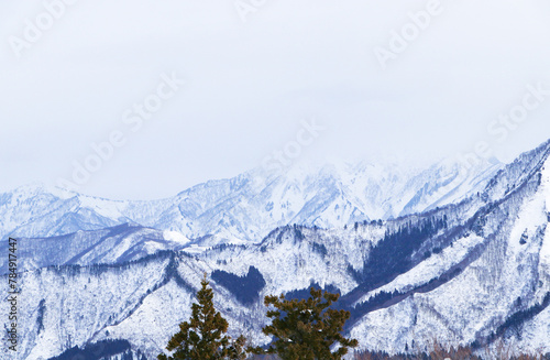 Mountain peak white snow in winter landscape in Japan. Fog covered dark sky. Awesome Beautiful Mountain tourism vacation. Great place for winter sports. Suitable for tourists and visiting citizens.