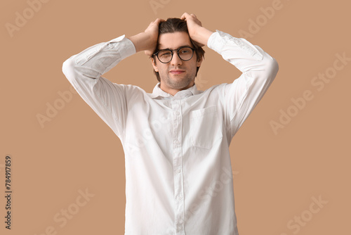 Weary young businessman on beige background