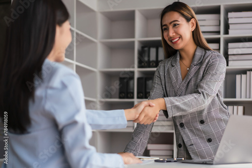 Two businesswoman shaking hands after discussion about new business project and deal together