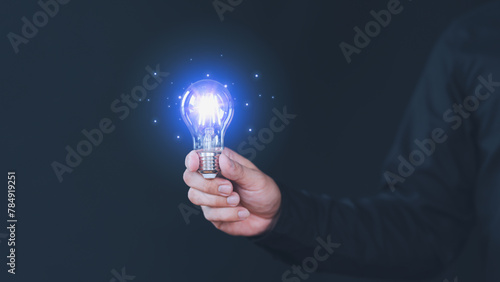 Freelancer hand holding illuminated light bulb. Creative idea, new business plan, motivation, innovation, inspiration. Energy saving light bulb. Concept of new ideas with innovation and creativity.