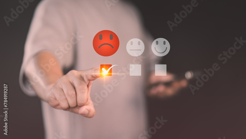 Customer hand touching the virtual screen on the angry emotion face. Assessment testimonial review for dislike service and low quality. Business concept of customer experience dissatisfied.