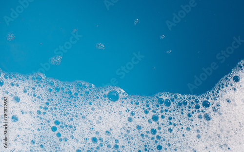 Detergent foam bubble on wate. Blue background, Soap sud © Bowonpat