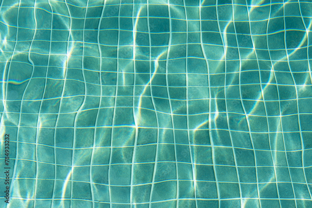 Obraz premium Water surface with waves on water surface wave effect You can see the blue square tiles at the bottom of the pool. 