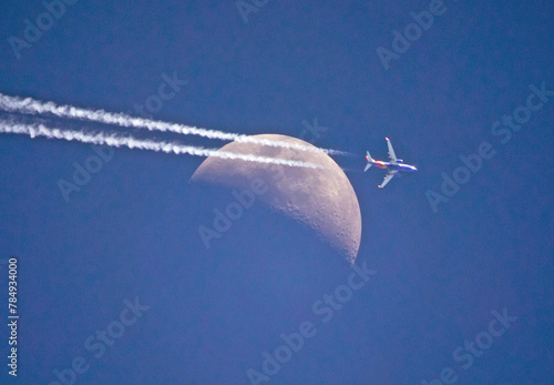 High Altitude Commercial Airliner Passing a Crescent Moon