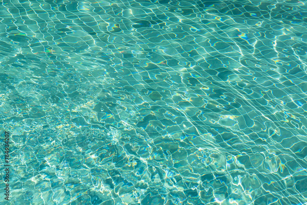 Water surface with waves on water surface wave effect You can see the blue square tiles at the bottom of the pool.	