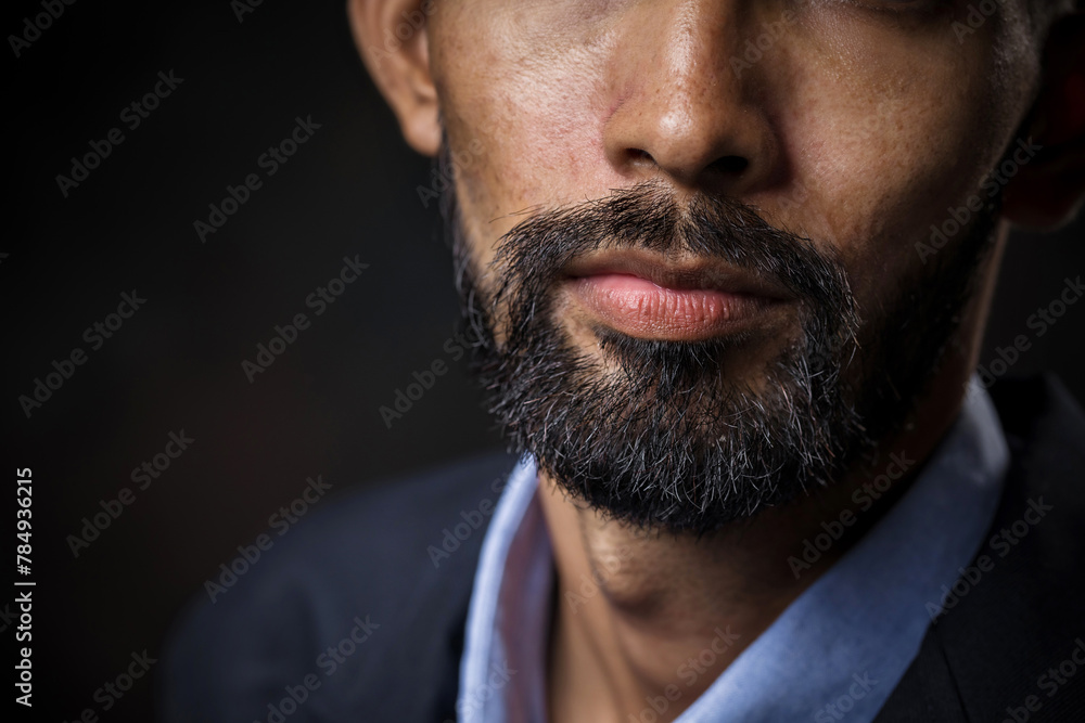 Close-up of business bearded man's face in a black studio, background. Close-up of business bearded man's face in a black studio, background.