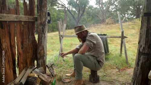A bushman eating meat stew in a historical bark hut in the Australian bush. photo
