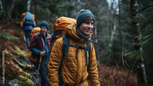 Happy backpacker and his friends hiking in forest
