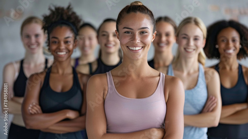 An inclusive and diverse group of women confidently posing together in a gym environment.