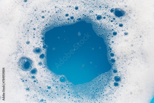Detergent foam bubble on wate. Blue background, Soap sud © Bowonpat