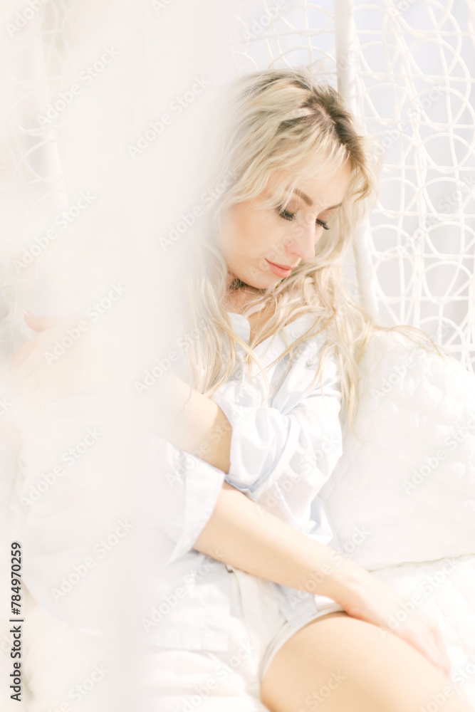 Woman Sitting on Bed Next to White Curtain Woman Sitting on Bed Next to White Curtain