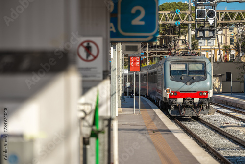 Passenger train arriving to the station of Brindisi in southern Italy, Puglia. Train approaching platform 2 on a sunny spring day.