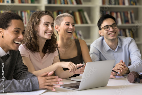 Quadro em tela Happy generation Z students sit at desk in college library, look away, engaged i