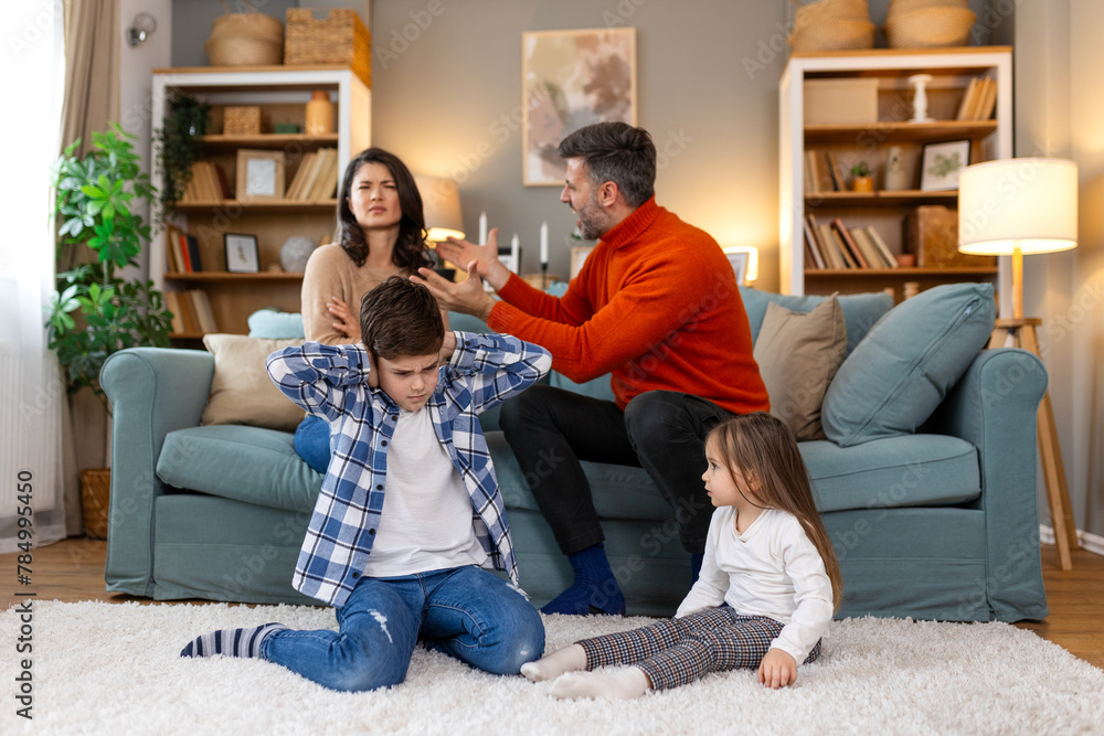 Divorce And Domestic Violence. Portrait of upset son and daughter while their angry parents fighting in the background, depressed children feeling lonely Divorce And Domestic Violence. Portrait of upset son and daughter while their angry parents fighting in the background, depressed children feeling lonely